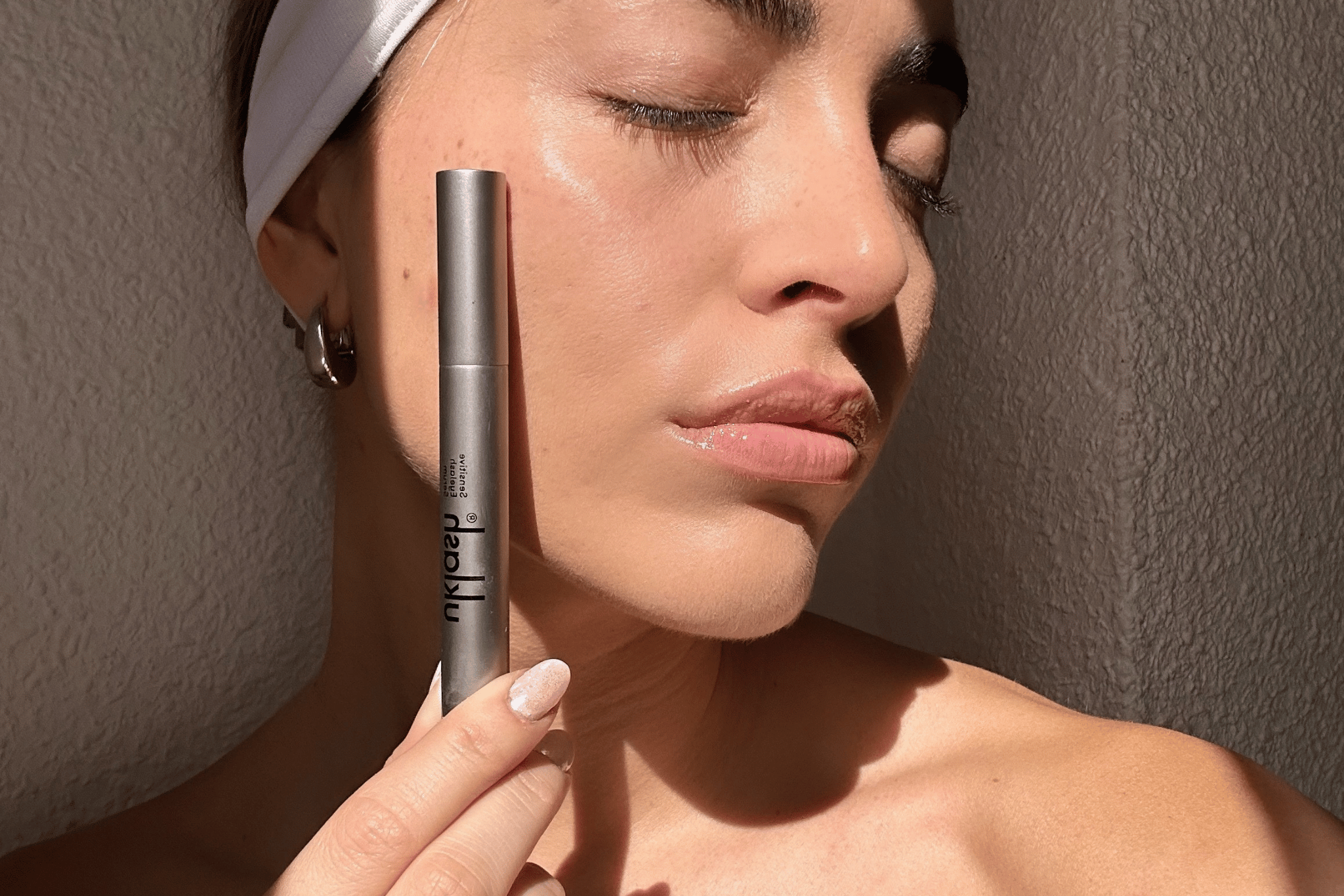 Chica utilizando UKLASH al invés de un sérum de pestañas barato.