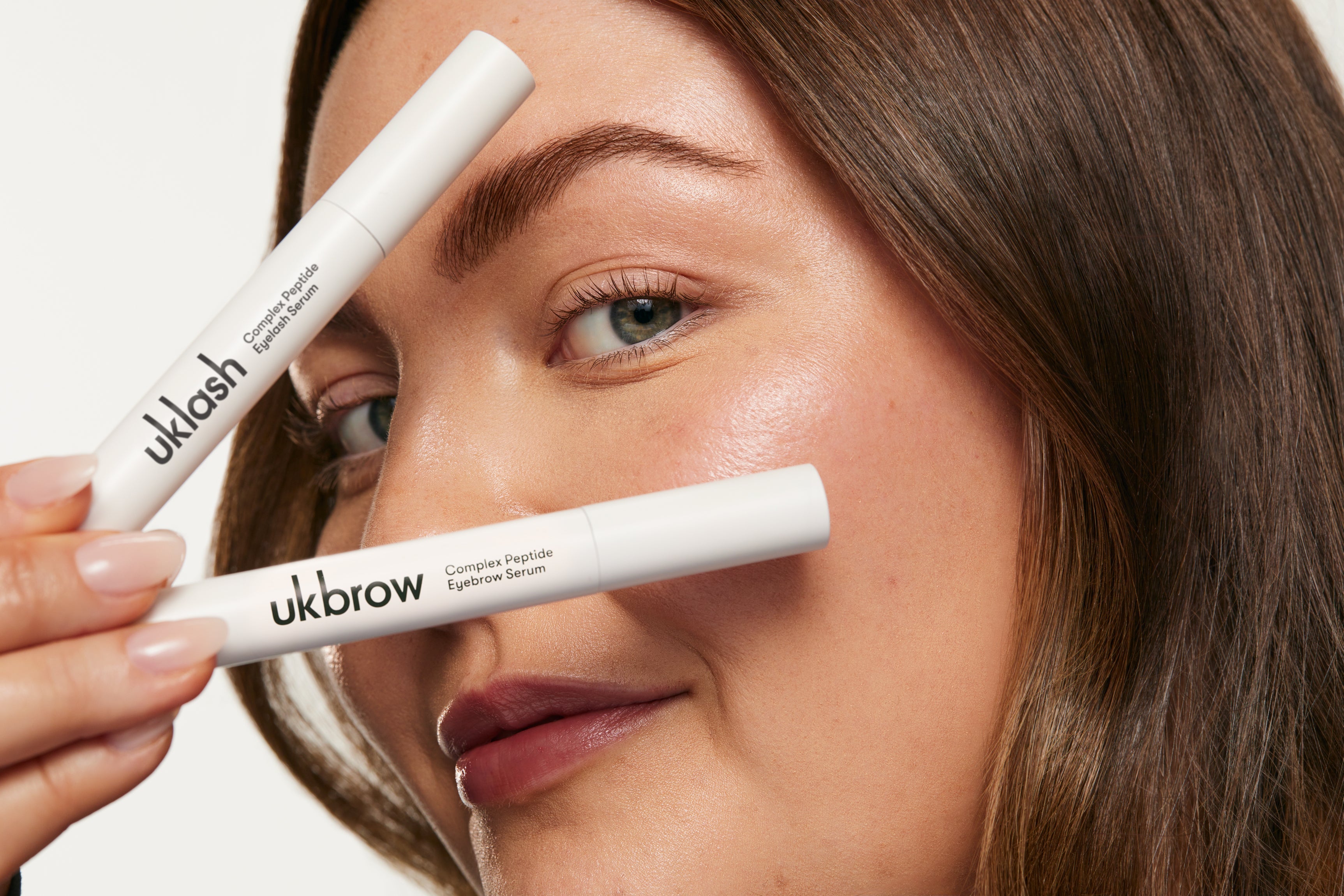 Chica enseñando productos de UKLASH con péptidos en la piel.