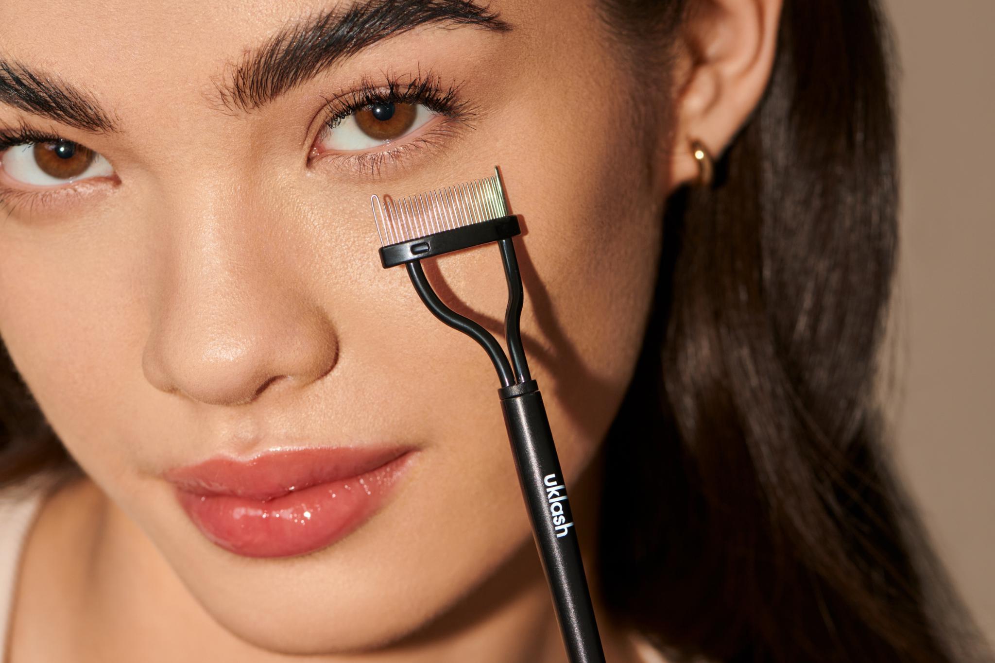 Modelo enseñando el cepillo de pestañas de UKLASH